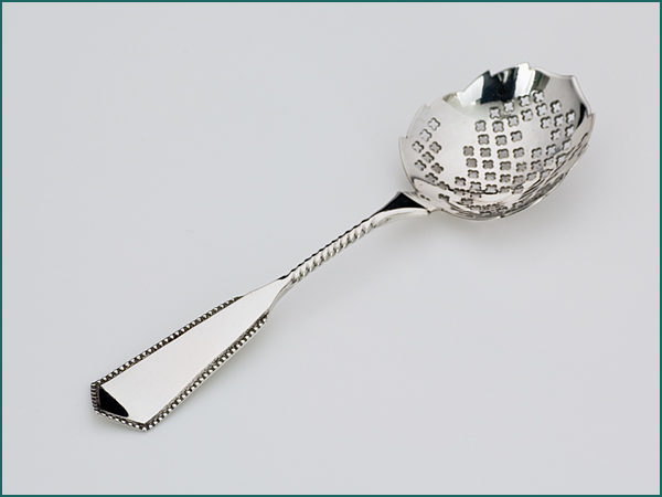 Zilveren strooi/natfruitlepeltje met parelrand uit 1909-0