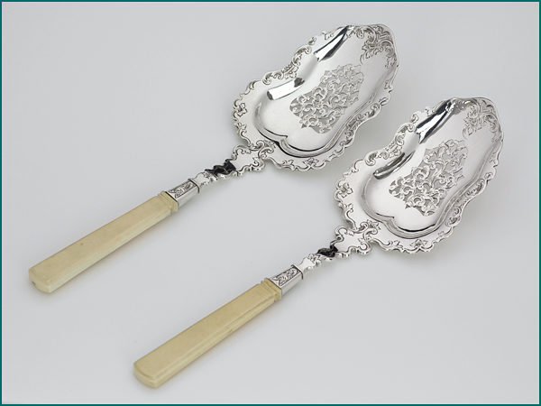Een stel zilveren natfruitscheppen met benen heften uit 1852-0